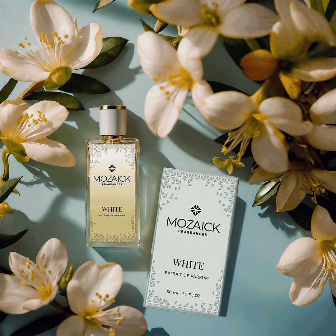 WHITE Extrait de Parfum 50 ml by MOZAICK – bottle and box with white blossoms on a light blue surface